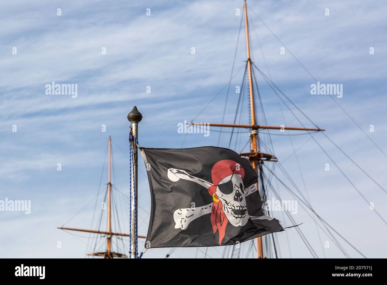 Un drapeau de roger ou de crâne et de crossos de jolly volant à l'intérieur avant du mât d'un ancien navire Banque D'Images