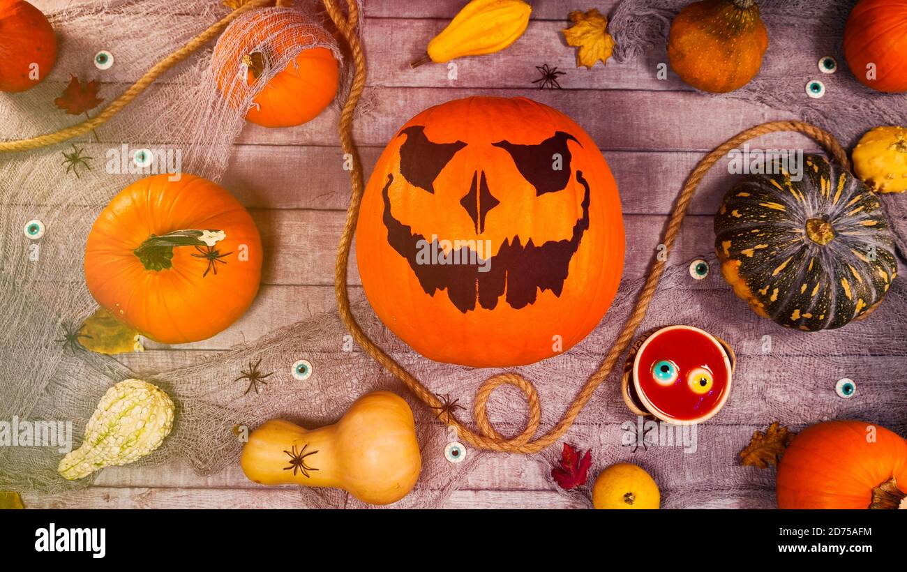 Citrouille automne halloween décor sur un bureau en bois. Une lanterne et des araignées effrayantes marchent entre les citrouilles. Scène effrayante d'halloween Banque D'Images