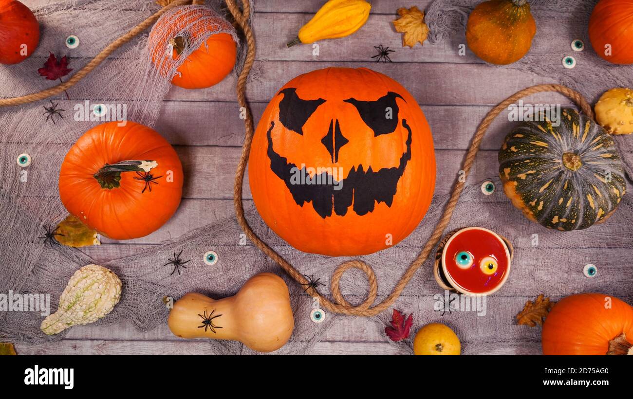 Citrouille automne halloween décor sur un bureau en bois. Une lanterne et des araignées effrayantes marchent entre les citrouilles. Scène effrayante d'halloween Banque D'Images