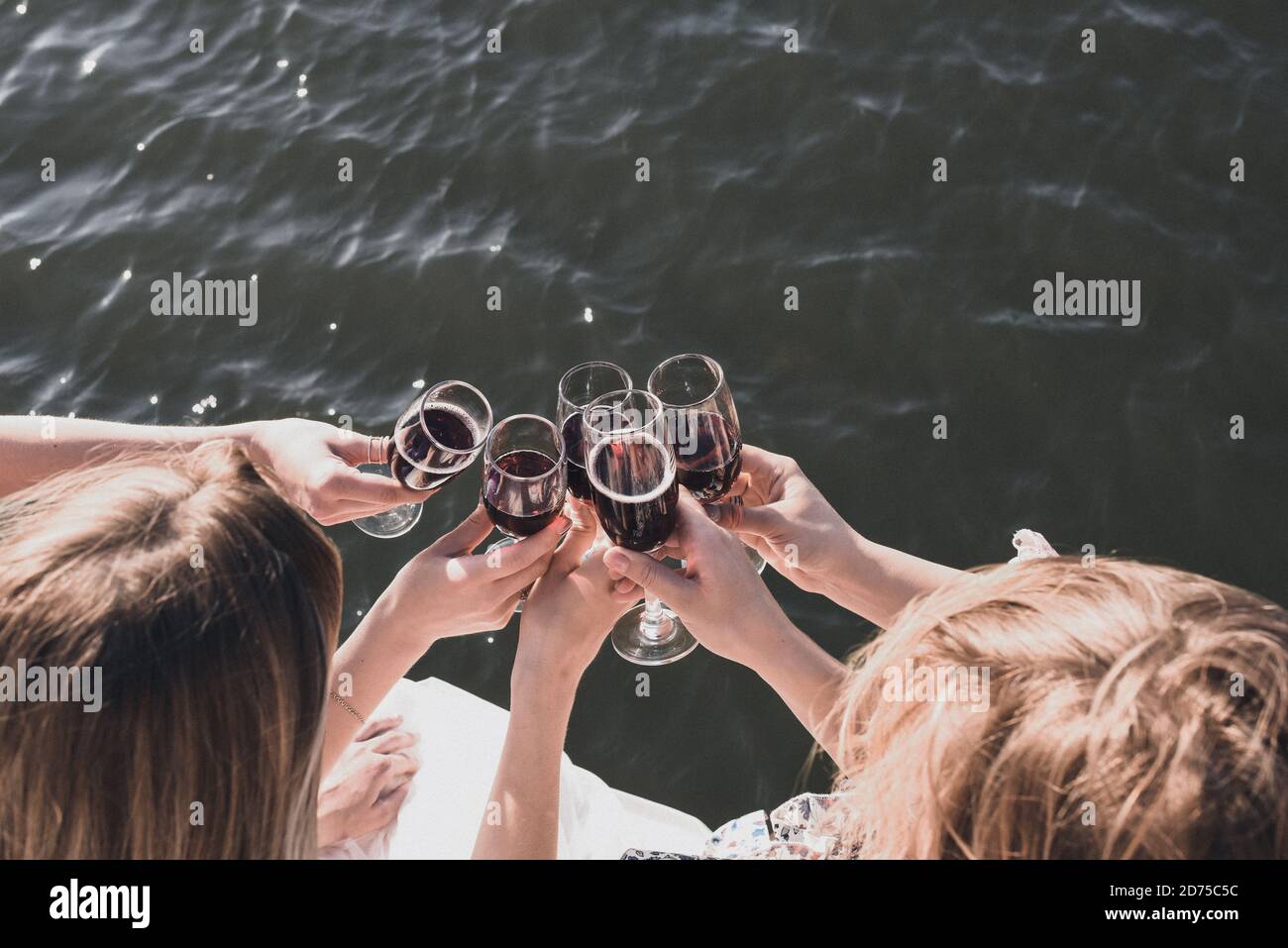 filles en robes à une fête de bachelorette buvant du vin rouge des lunettes Banque D'Images