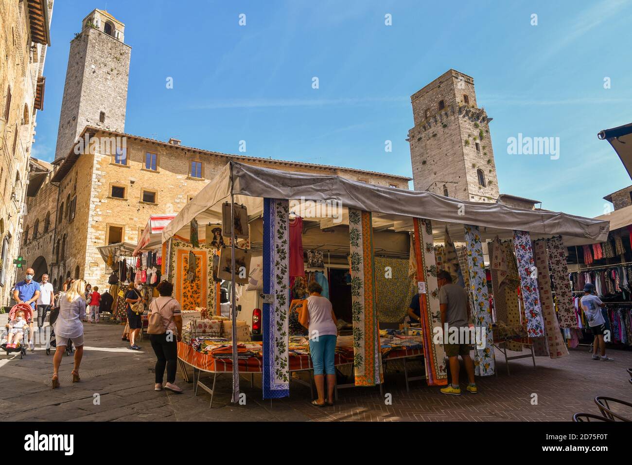 Piazza della Cisterna dans la vieille ville de San Gimignano, UNESCO W.H. Site, avec la Torre del Diavolo pendant le marché hebdomadaire, Sienne, Toscane, Italie Banque D'Images