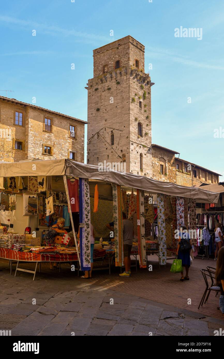 Piazza della Cisterna dans la vieille ville de San Gimignano, UNESCO W.H. Site, avec la Torre del Diavolo pendant le marché hebdomadaire, Sienne, Toscane, Italie Banque D'Images