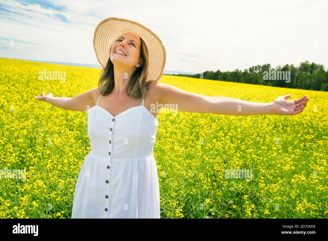 belle jeune femme heureuse sur champ de colza en fleur Banque D'Images