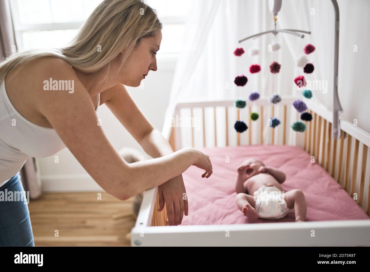 mère souffrant de dépression postnatale près de berceau avec bébé mignon à la maison Banque D'Images