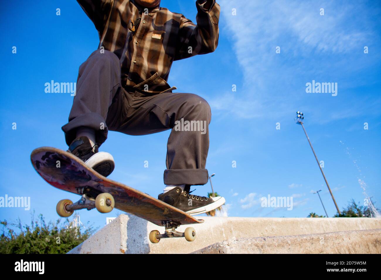 Homme sportif avec des vêtements amples longboard et faire des tours avec  son skate coloré et cool Photo Stock - Alamy