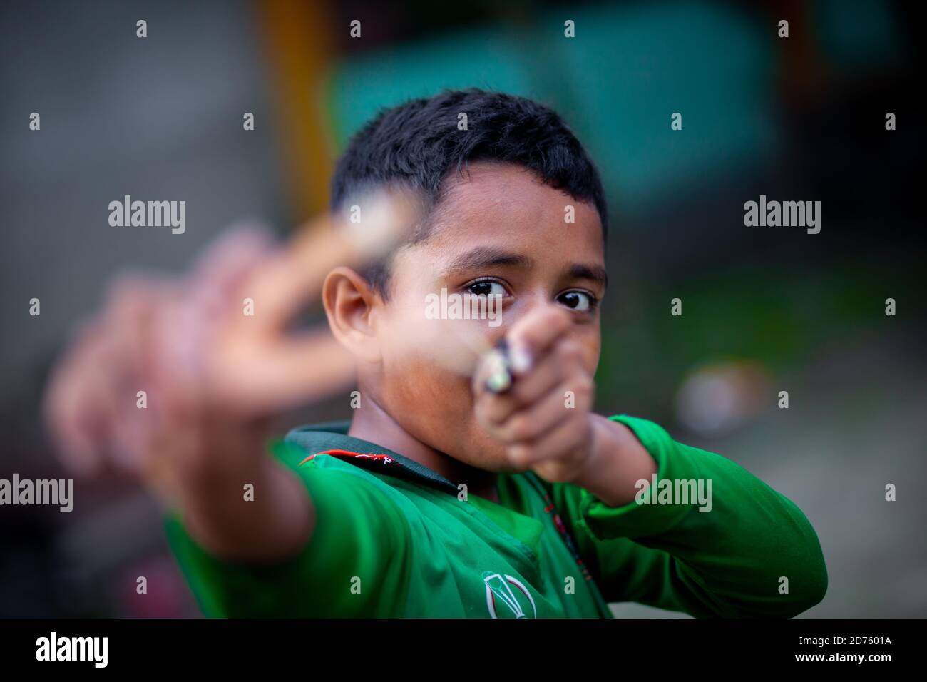 Bangladesh – 04 octobre 2020 : un gamin de cricket du Bangladesh portant un maillot de cricket qui tira un coup de feu en bois à Barinagar, Jessore. Banque D'Images