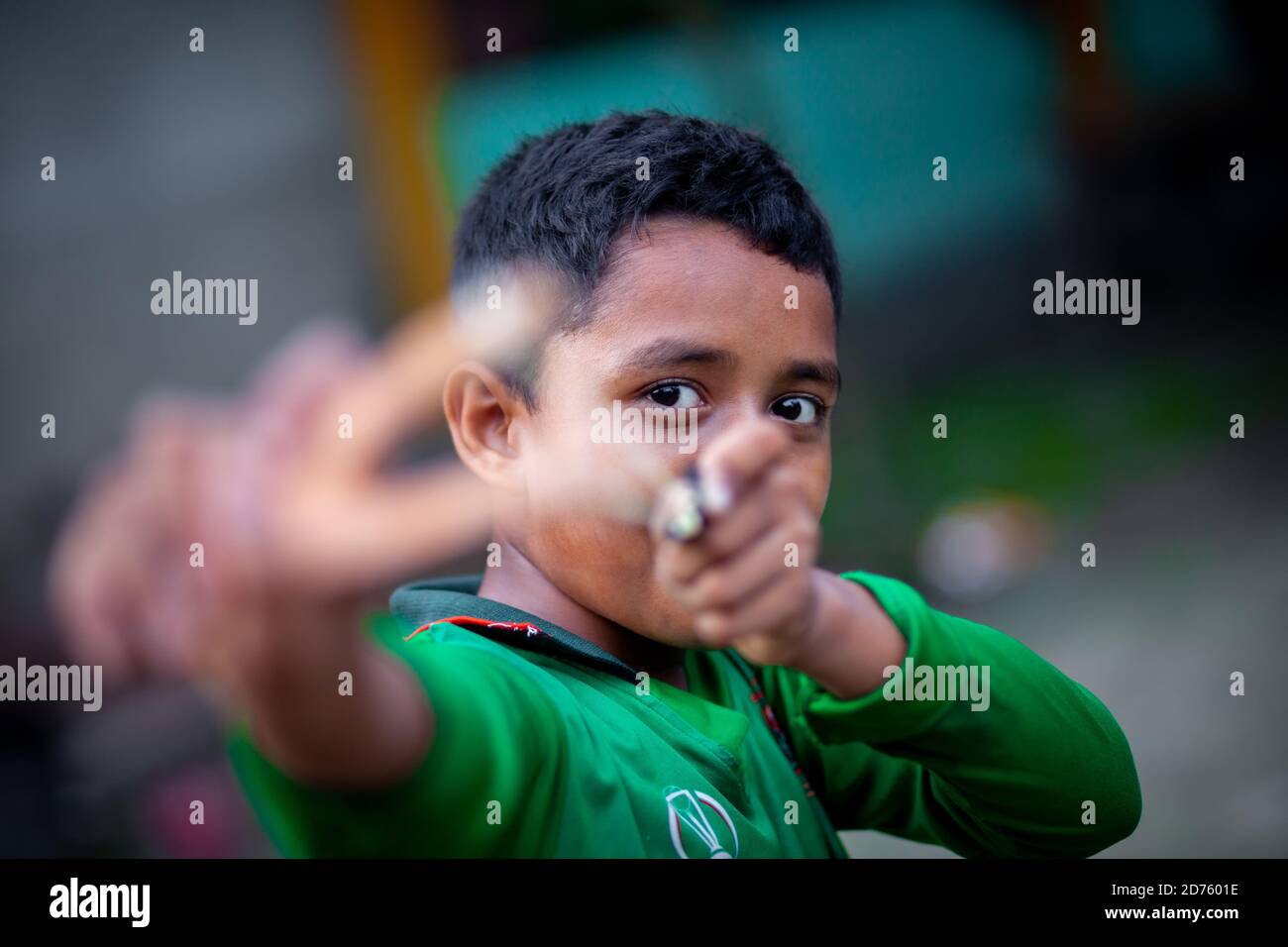 Bangladesh – 04 octobre 2020 : un gamin de cricket du Bangladesh portant un maillot de cricket qui tira un coup de feu en bois à Barinagar, Jessore. Banque D'Images
