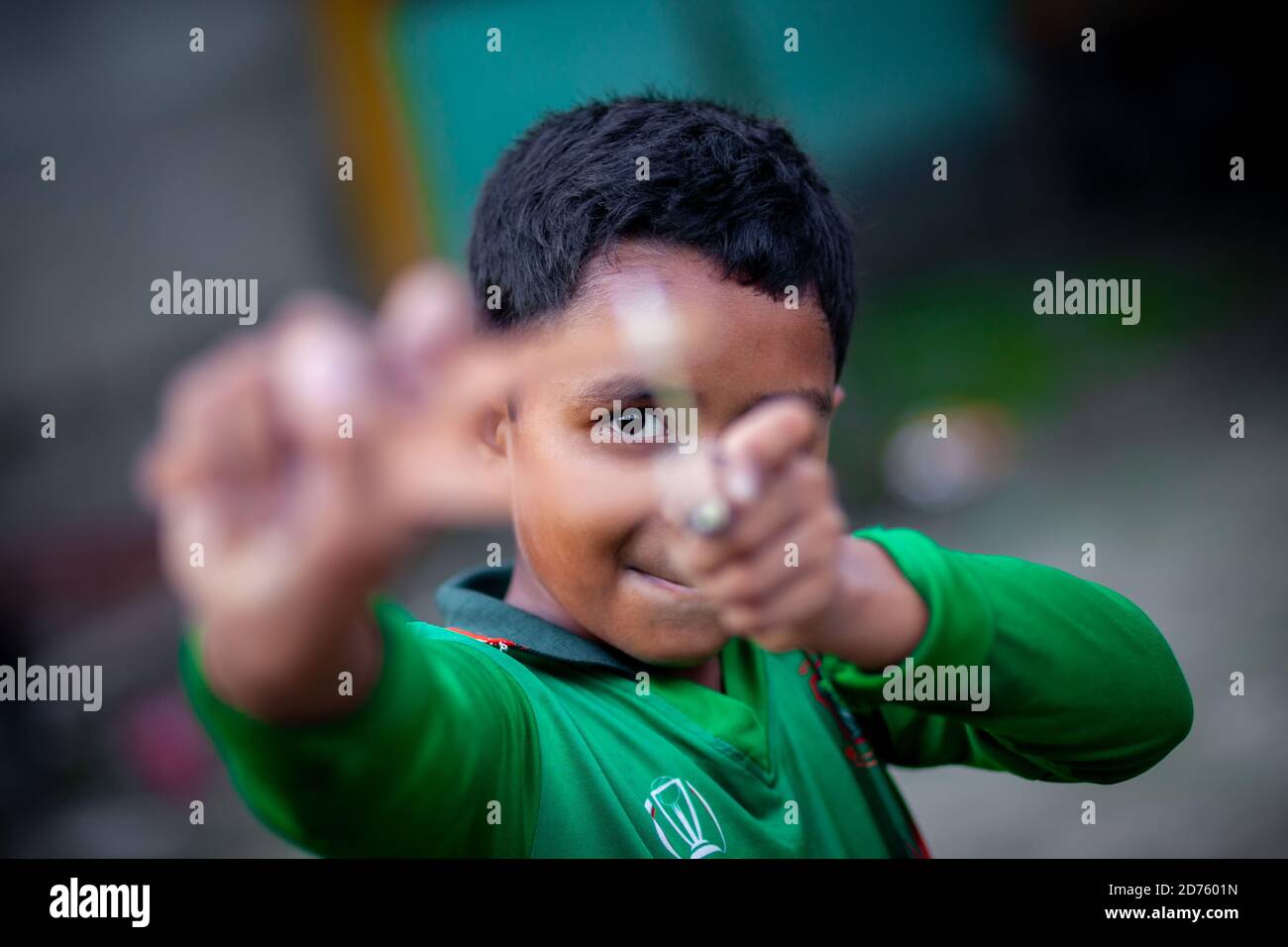 Bangladesh – 04 octobre 2020 : un gamin de cricket du Bangladesh portant un maillot de cricket qui tira un coup de feu en bois à Barinagar, Jessore. Banque D'Images