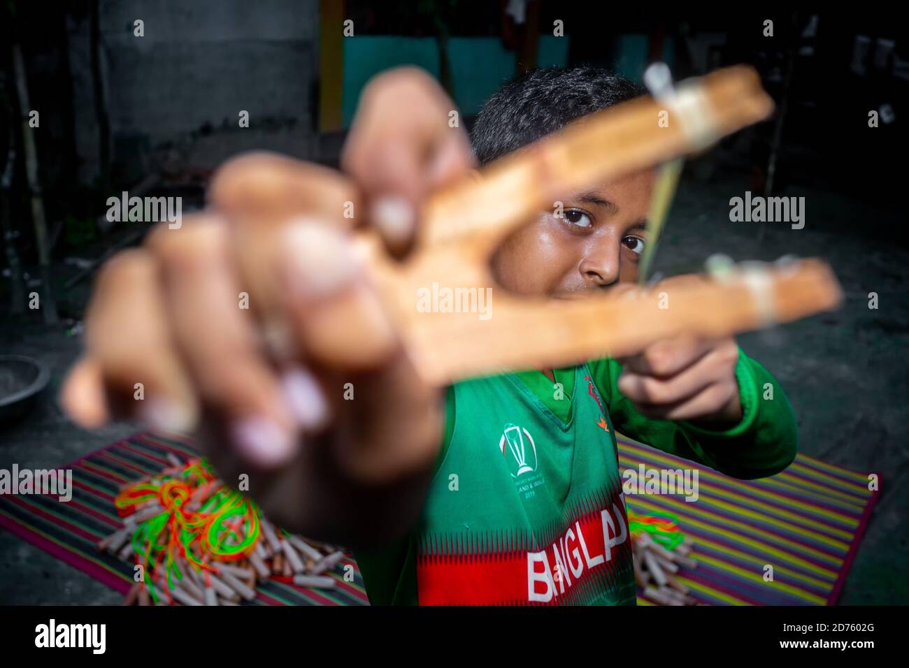 Bangladesh – 04 octobre 2020 : un gamin de cricket du Bangladesh portant un maillot de cricket qui tira un coup de feu en bois à Barinagar, Jessore. Banque D'Images