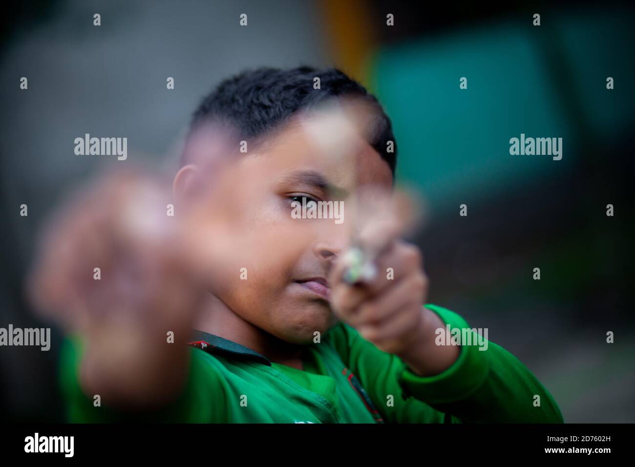 Bangladesh – 04 octobre 2020 : un gamin de cricket du Bangladesh portant un maillot de cricket qui tira un coup de feu en bois à Barinagar, Jessore. Banque D'Images