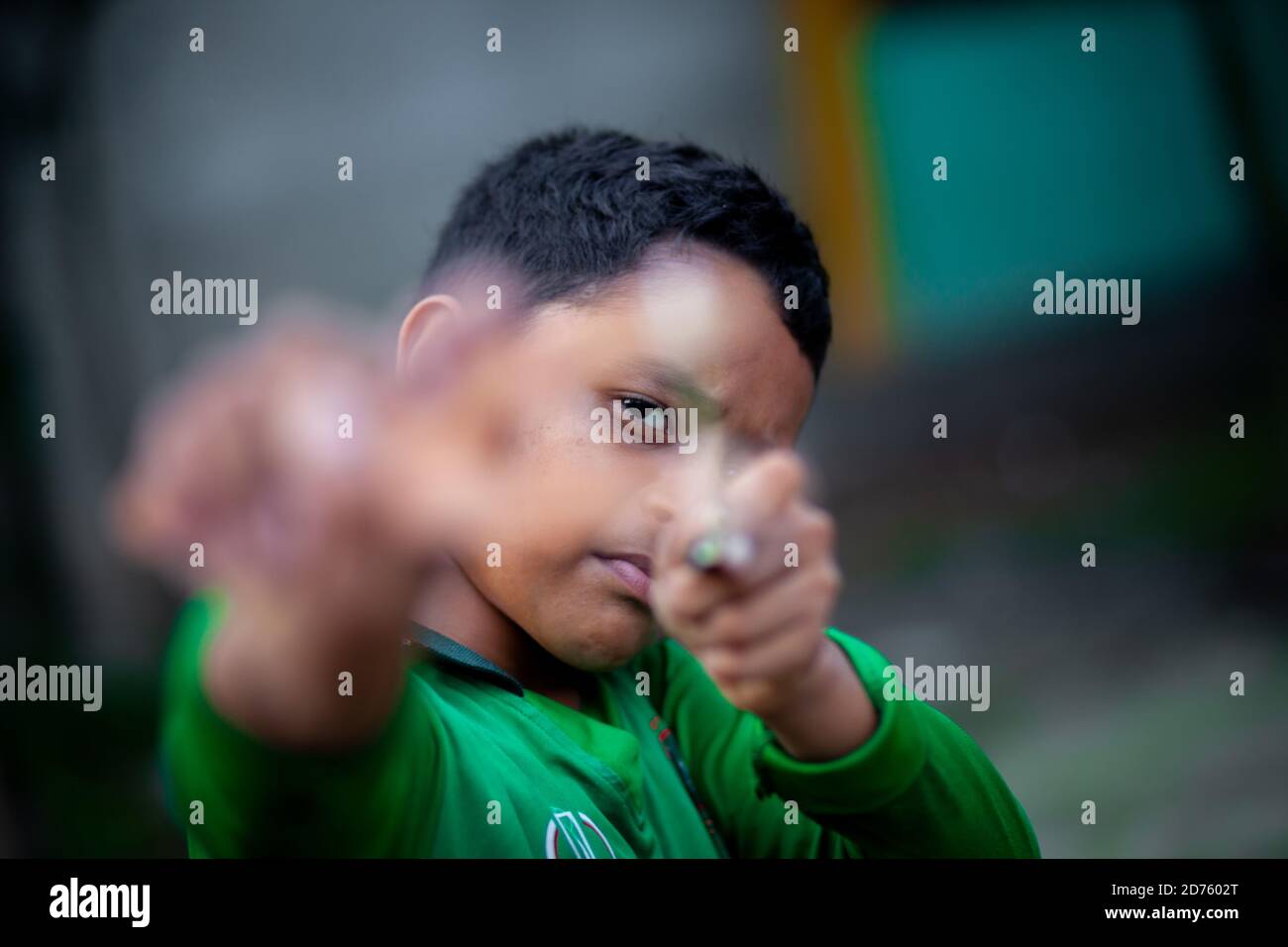 Bangladesh – 04 octobre 2020 : un gamin de cricket du Bangladesh portant un maillot de cricket qui tira un coup de feu en bois à Barinagar, Jessore. Banque D'Images