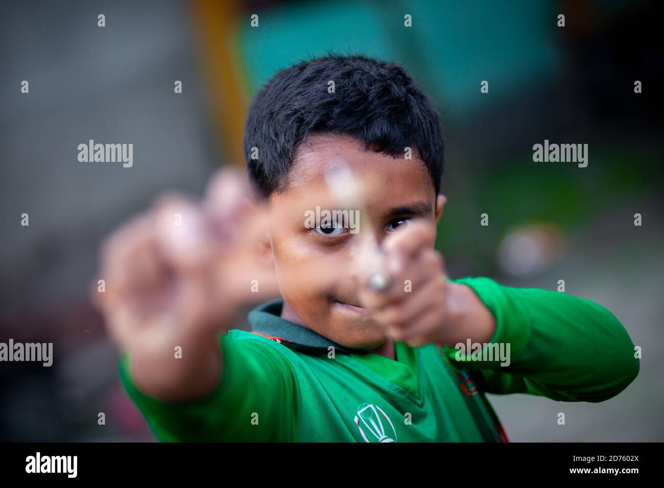Bangladesh – 04 octobre 2020 : un gamin de cricket du Bangladesh portant un maillot de cricket qui tira un coup de feu en bois à Barinagar, Jessore. Banque D'Images