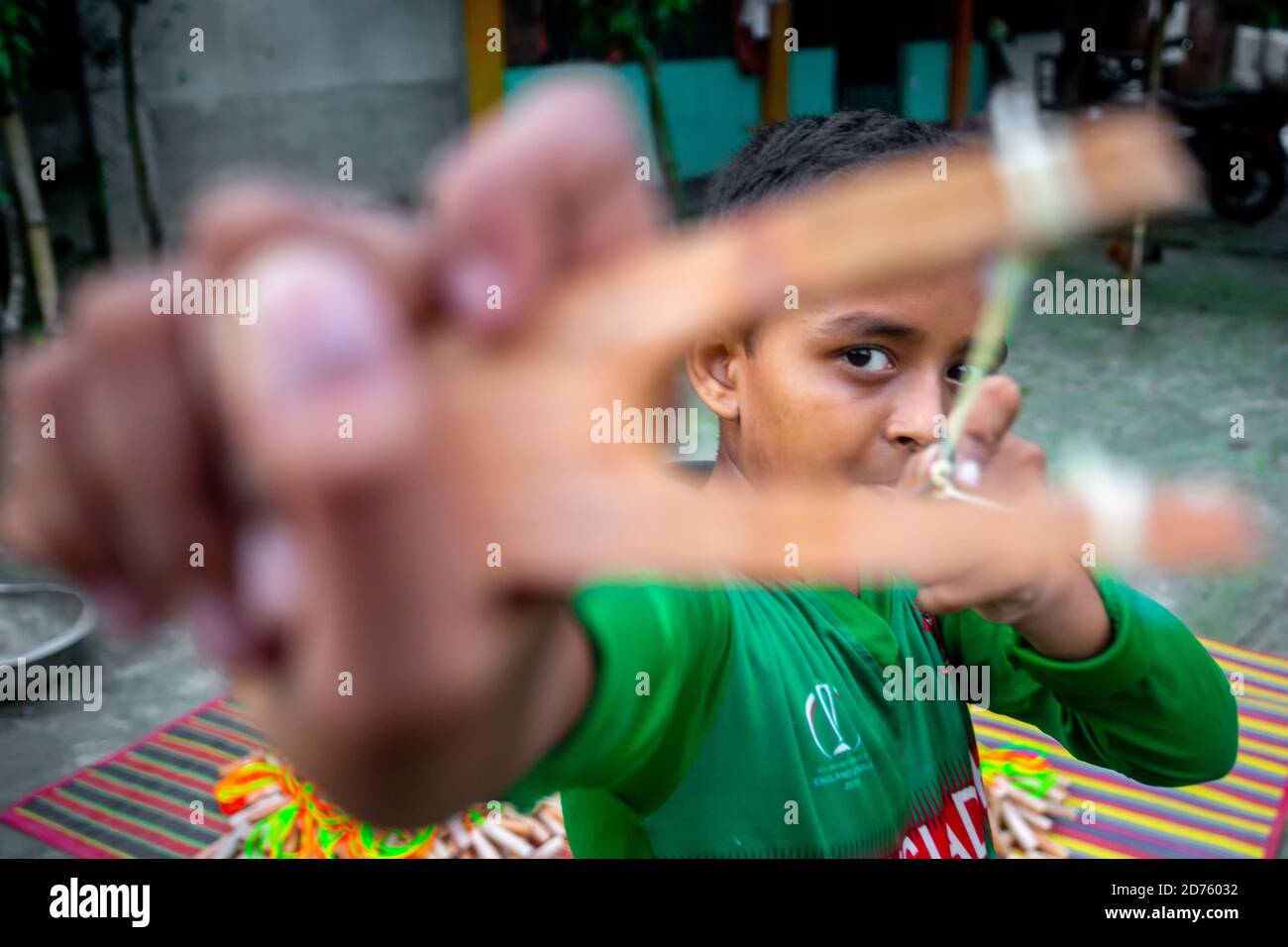 Bangladesh – 04 octobre 2020 : un gamin de cricket du Bangladesh portant un maillot de cricket qui tira un coup de feu en bois à Barinagar, Jessore. Banque D'Images
