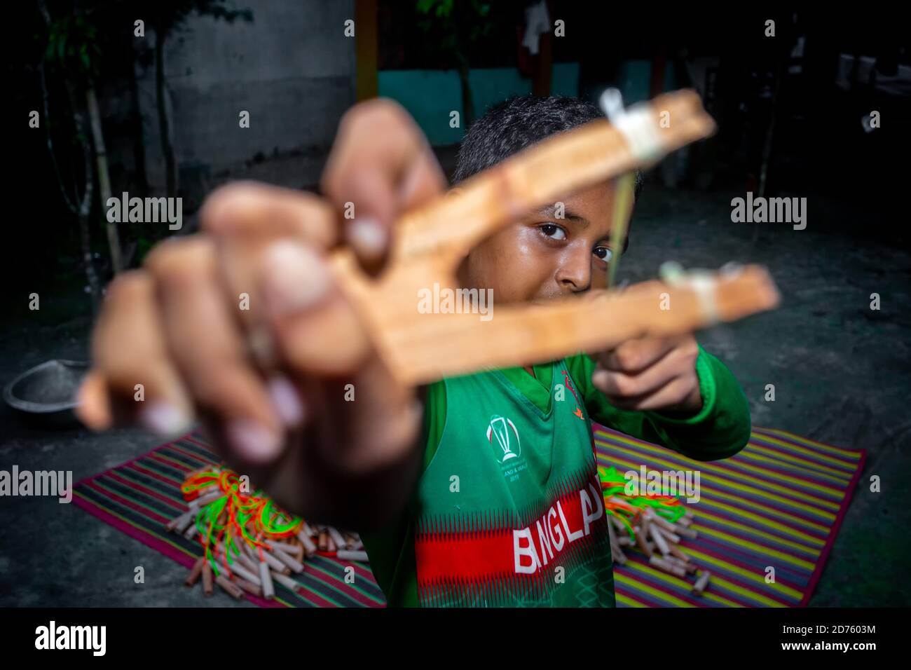 Bangladesh – 04 octobre 2020 : un gamin de cricket du Bangladesh portant un maillot de cricket qui tira un coup de feu en bois à Barinagar, Jessore. Banque D'Images