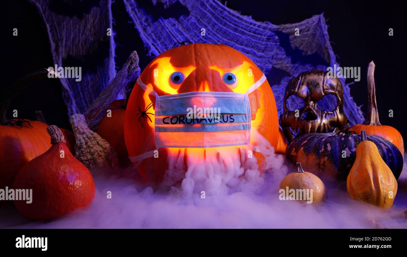 Halloween pendant la pandémie du coronavirus. Jack o lanterne citrouille dans un masque médical. Citrouilles d'Halloween sur fond sinistre, brouillard brumeux. Banque D'Images
