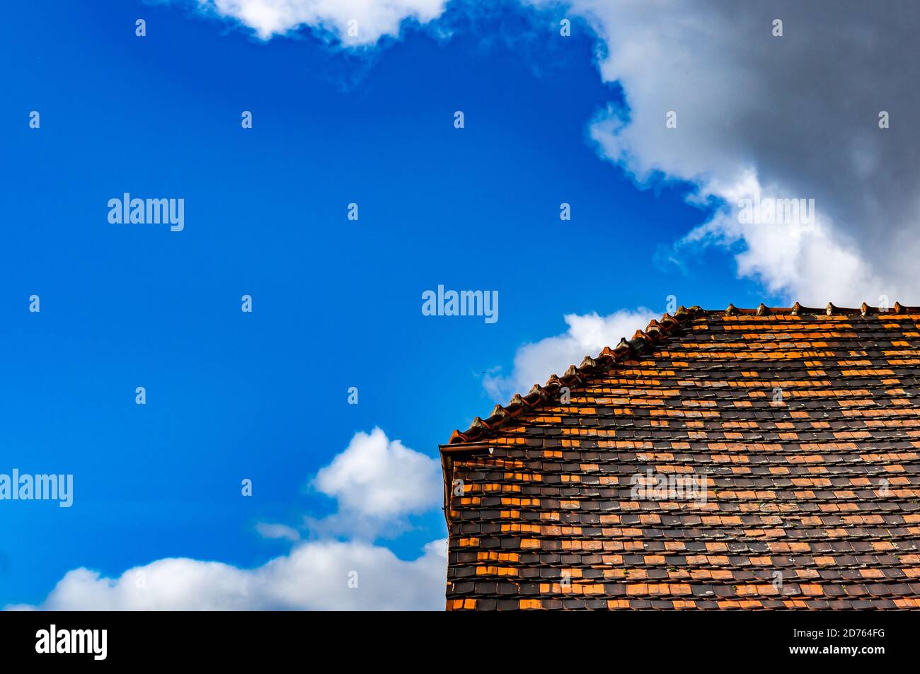 Gros plan d'un toit en tuiles sous un ciel nuageux ciel Banque D'Images