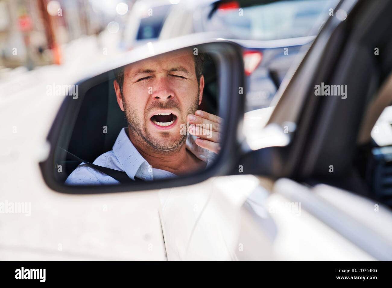 l'homme bâille dans sa voiture parce qu'il est si fatigué Banque D'Images