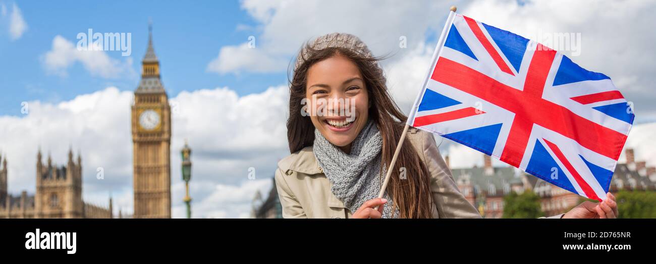 Femme touristique de voyage à Londres avec bannière drapeau de Grande-Bretagne montrant l'icône Union Jack. Royaume-Uni destination de vacances asiatique chinoise fille tenant Uni Banque D'Images