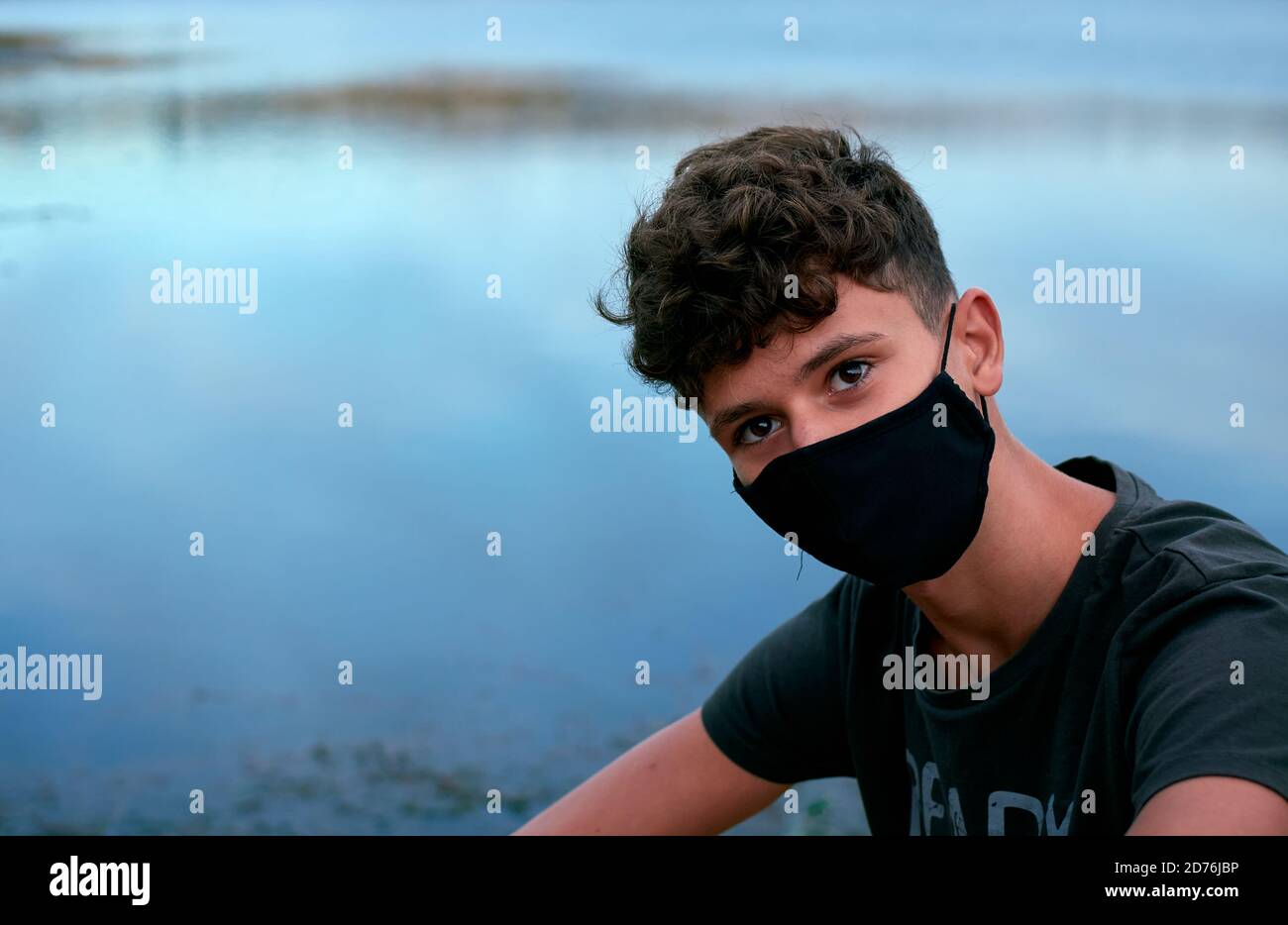 Jeune homme caucasien portant un masque noir Banque D'Images