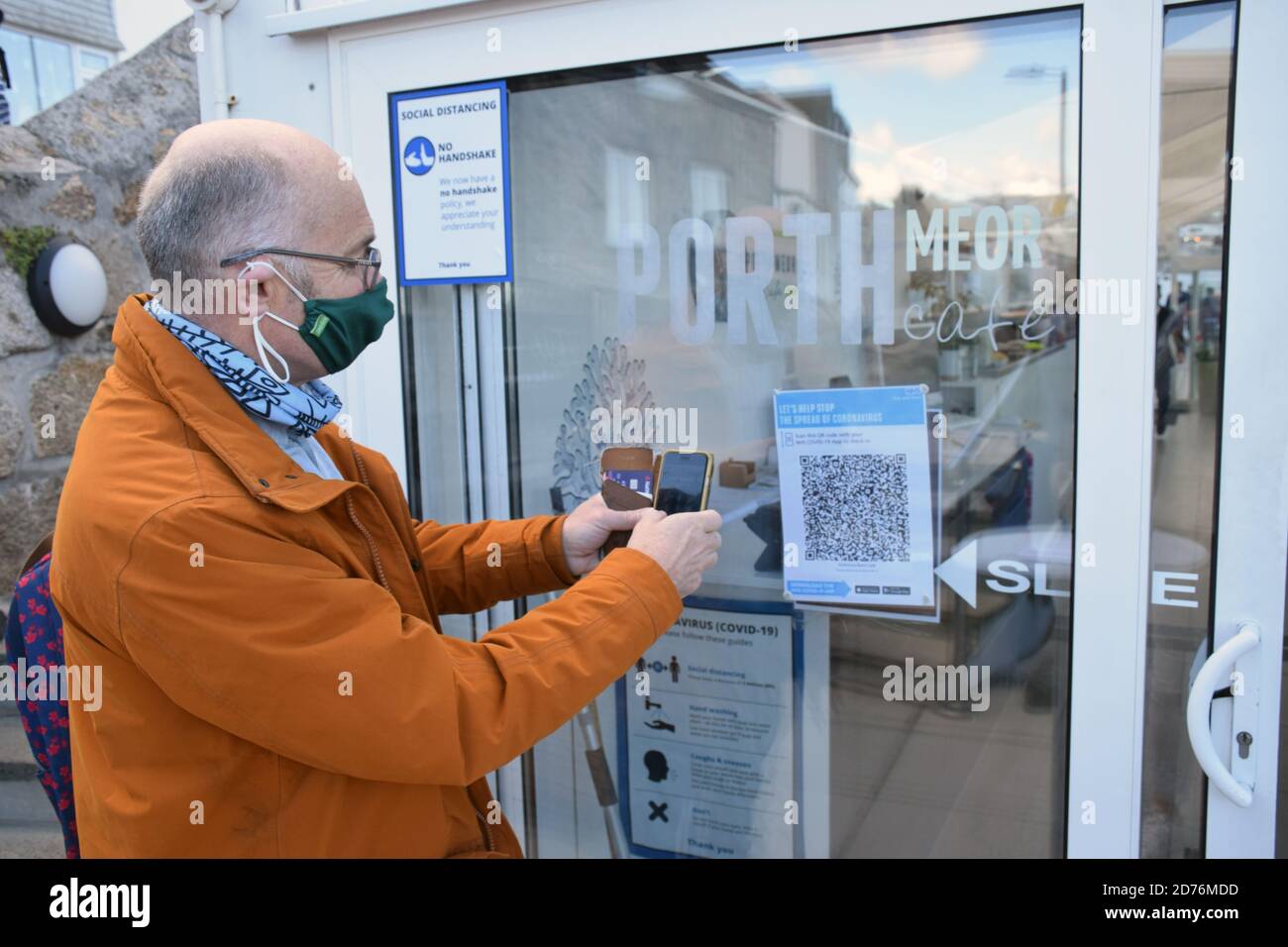 Homme utilisant l'application NHS coronavirus Track and Trace au café de la plage de Porthmeor, St Ives, Cornwall, Royaume-Uni oct 2020 MR Banque D'Images