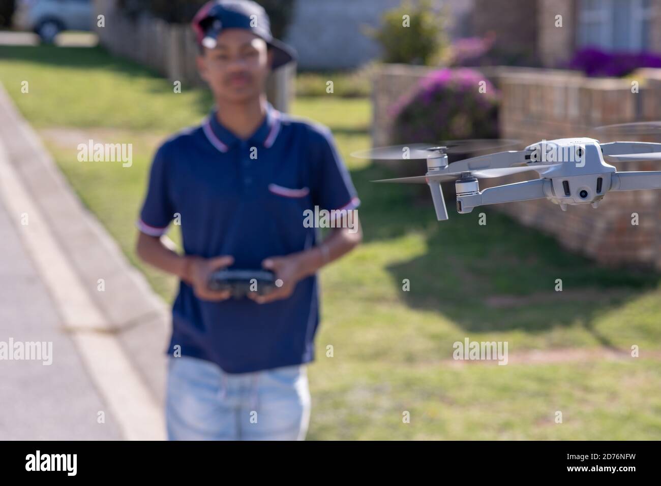 Drone planant en plein air avec un arrière-plan flou d'un jeune garçon contrôlant à distance. Photo de haute qualité Banque D'Images