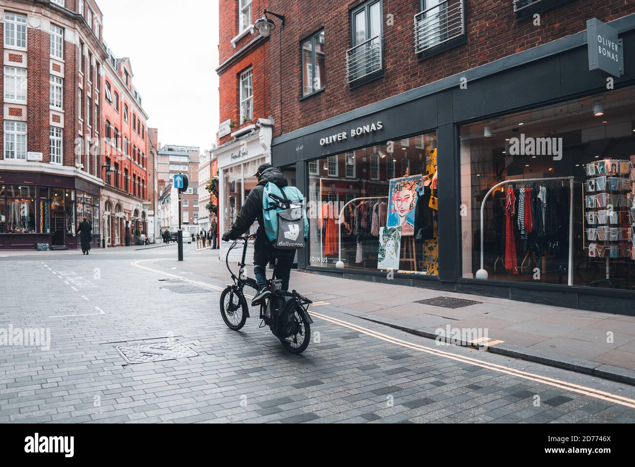 LONDRES, ROYAUME-UNI-21 MARS 2019. Une compagnie de livraison de cycliste Deliveroo qui s'accélère dans les rues de la ville avec une livraison de nourriture chaude à partir de plats à emporter et de restaurants Banque D'Images