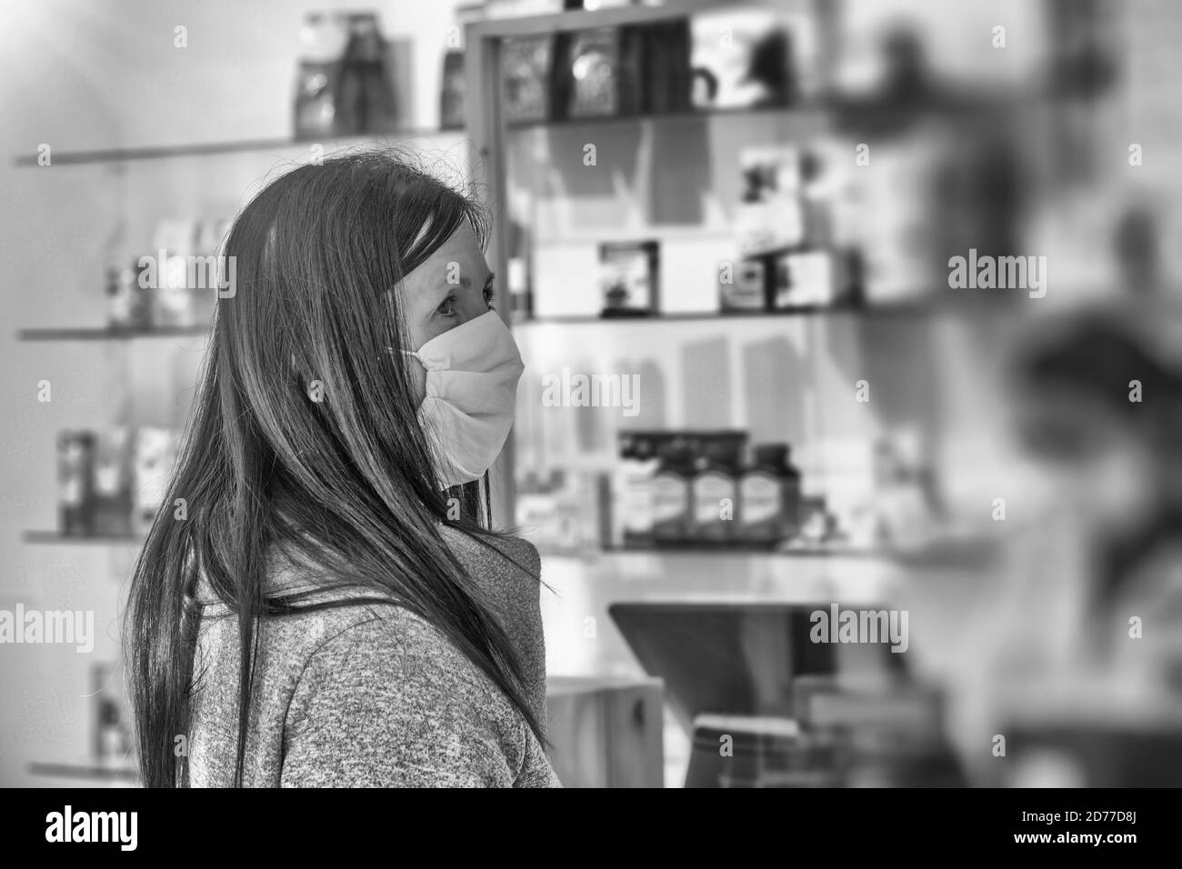 Femme portant un masque de santé à la pharmacie achetant des articles médicaux en cas de pandémie de covid Banque D'Images