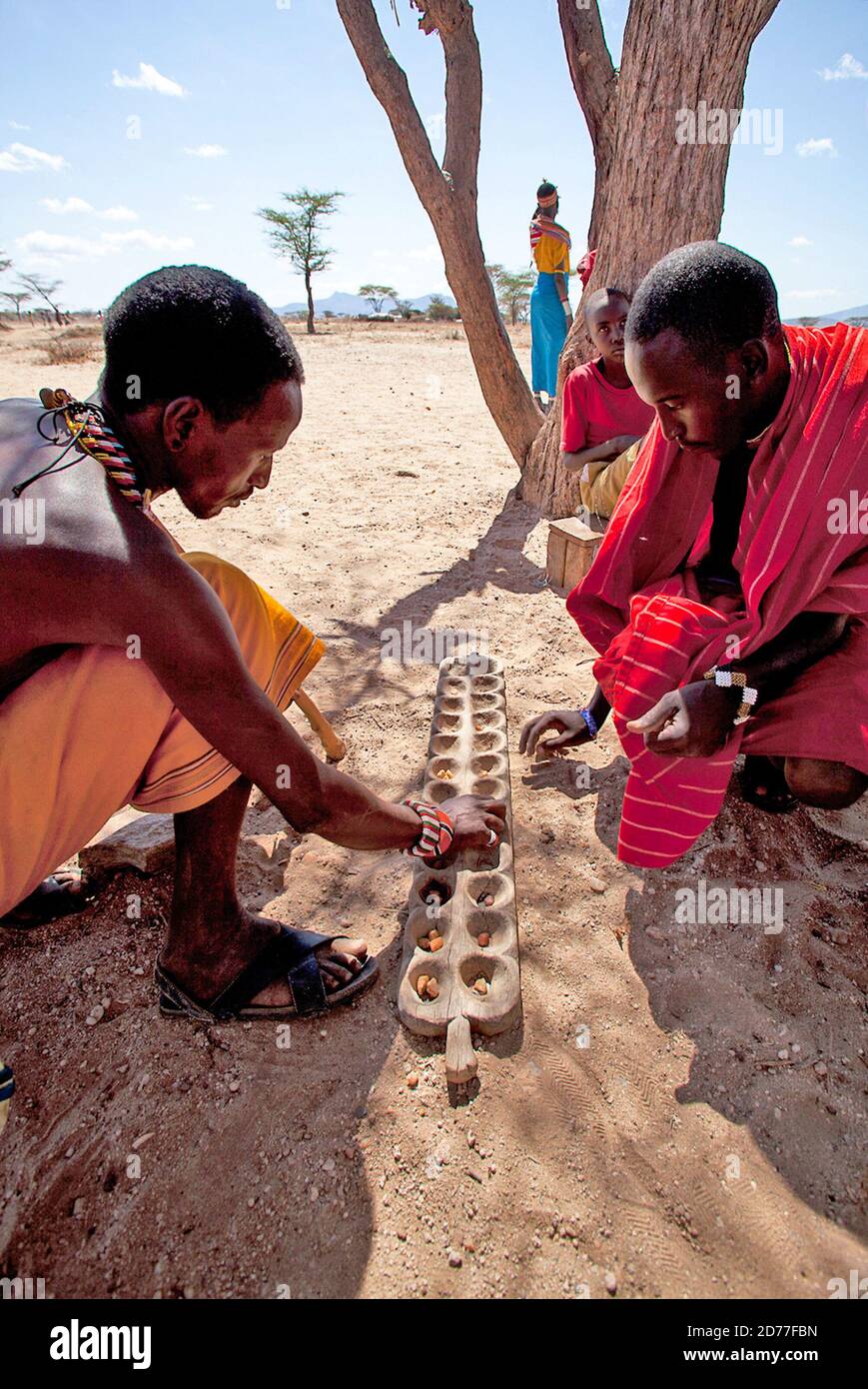 Les jeunes hommes de la tribu Samburu jouent Mancala. Mancala est l'un des plus anciens jeux connus pour être encore largement joué aujourd'hui. Mancala est un nom générique pour un Banque D'Images