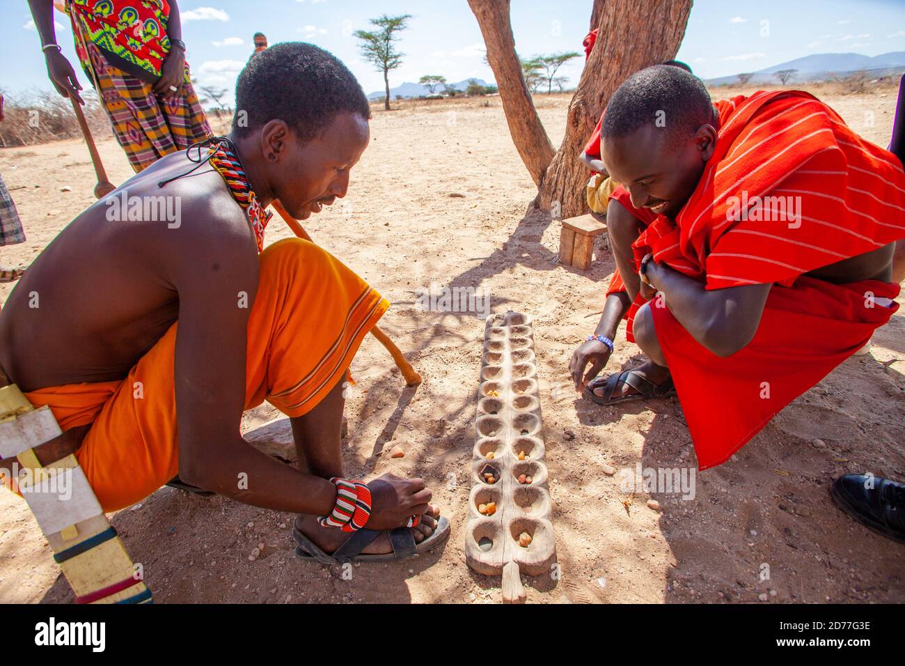 Les jeunes hommes de la tribu Samburu jouent Mancala. Mancala est l'un des plus anciens jeux connus pour être encore largement joué aujourd'hui. Mancala est un nom générique pour un Banque D'Images