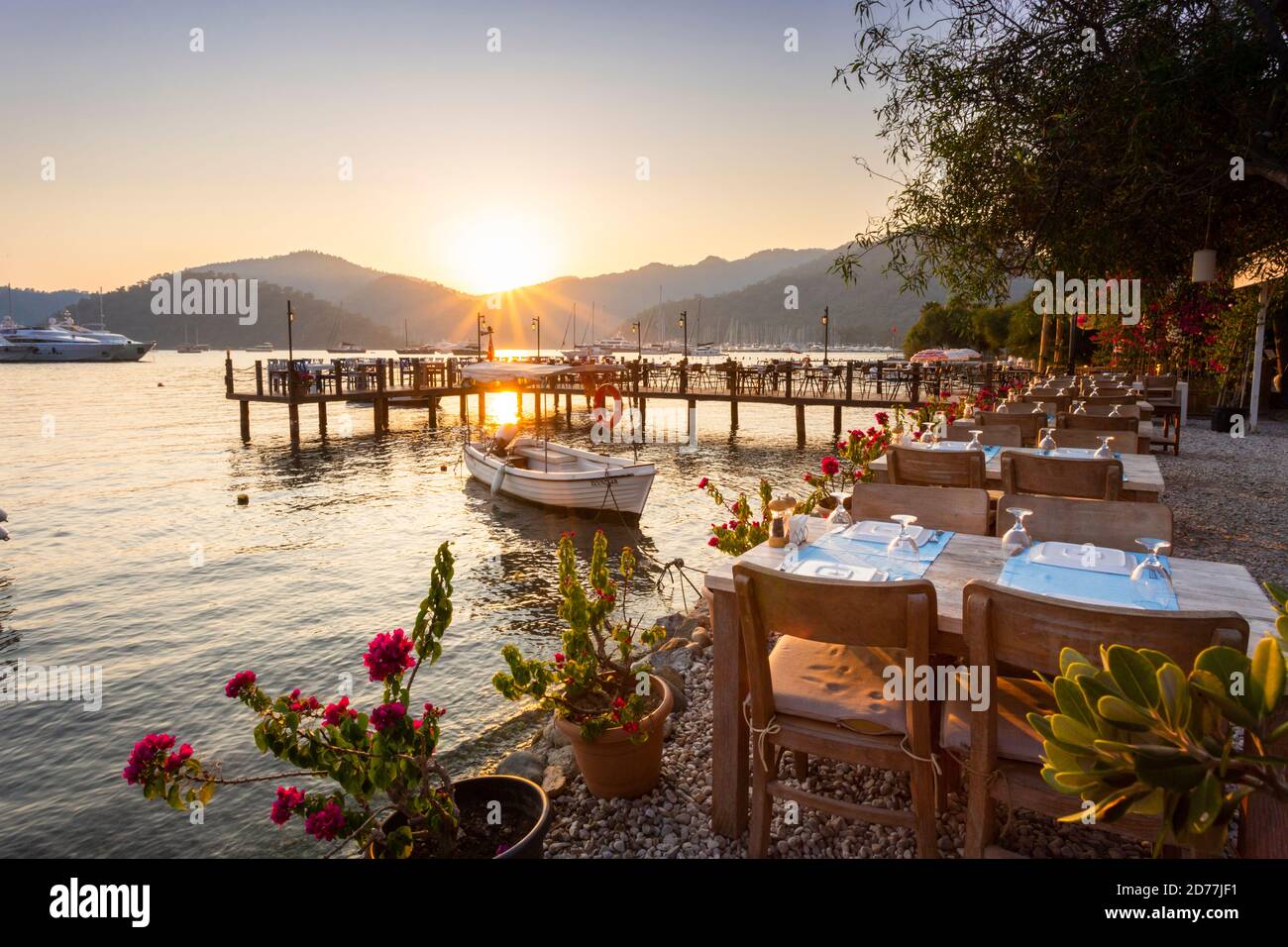 Vue sur le coucher du soleil d'un restaurant en bord de mer au port de Göcek, province de Muğla, Turquie Banque D'Images