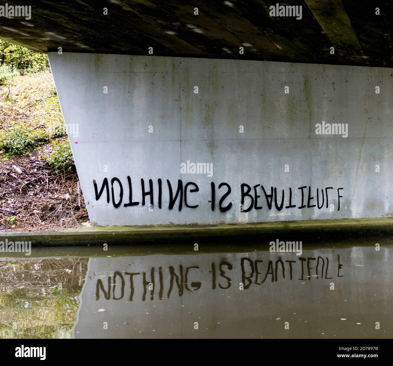 Graffiti sur le pont de canal destiné à lire la bonne façon vers le haut dans son reflet Banque D'Images