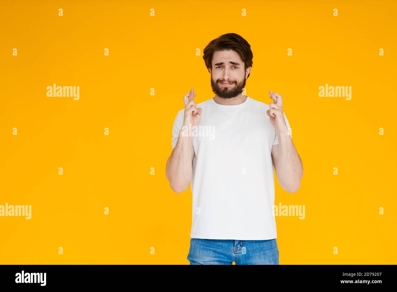 Sourire barbu homme gars en blanc décontracté t-shirt isolé sur fond jaune. Concept de mode de vie des personnes. Créer un espace de copie. En attente de spécial Banque D'Images
