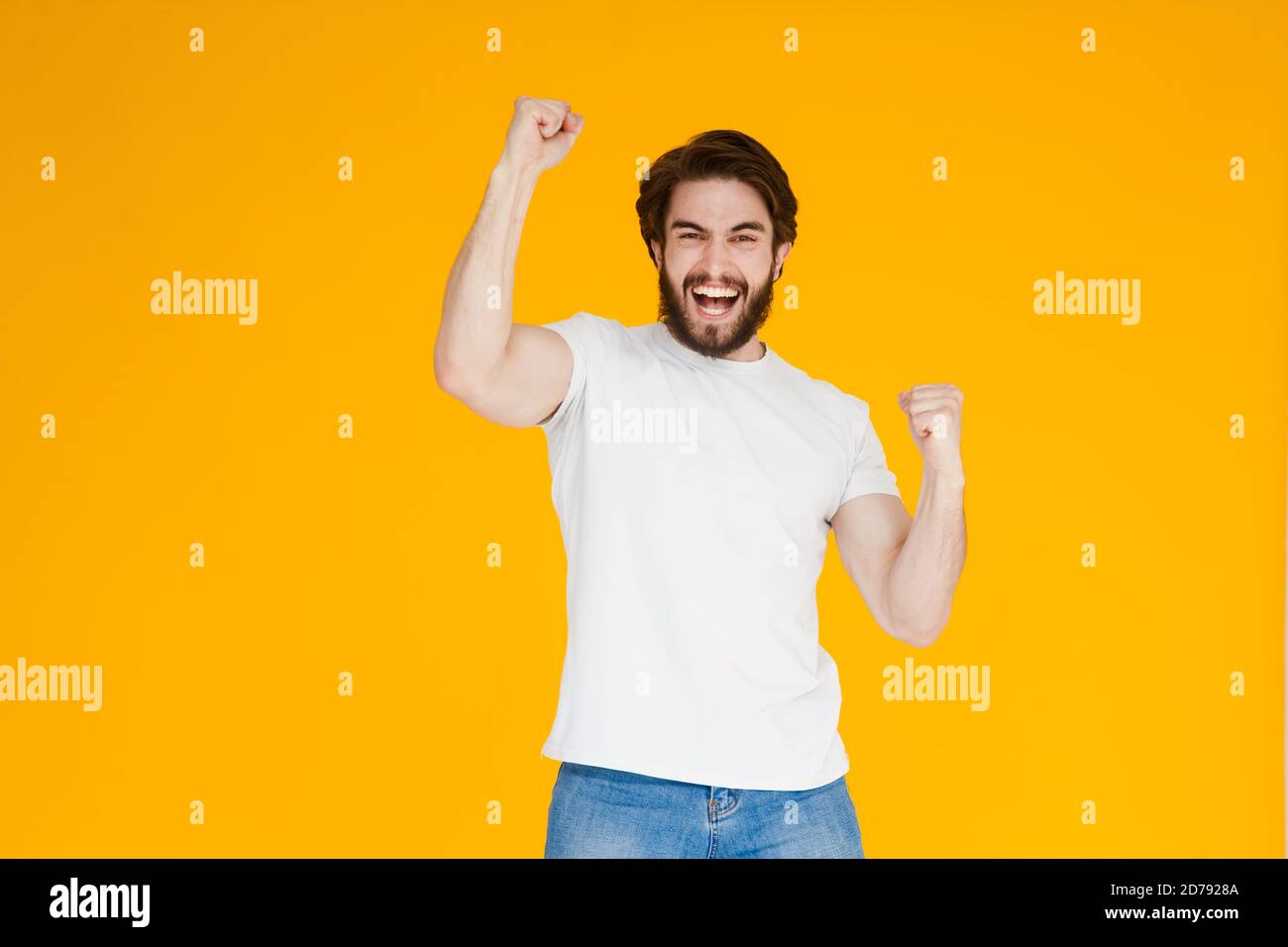 Portrait d'un homme barbu joyeux célébrant le succès isolé arrière-plan jaune Banque D'Images