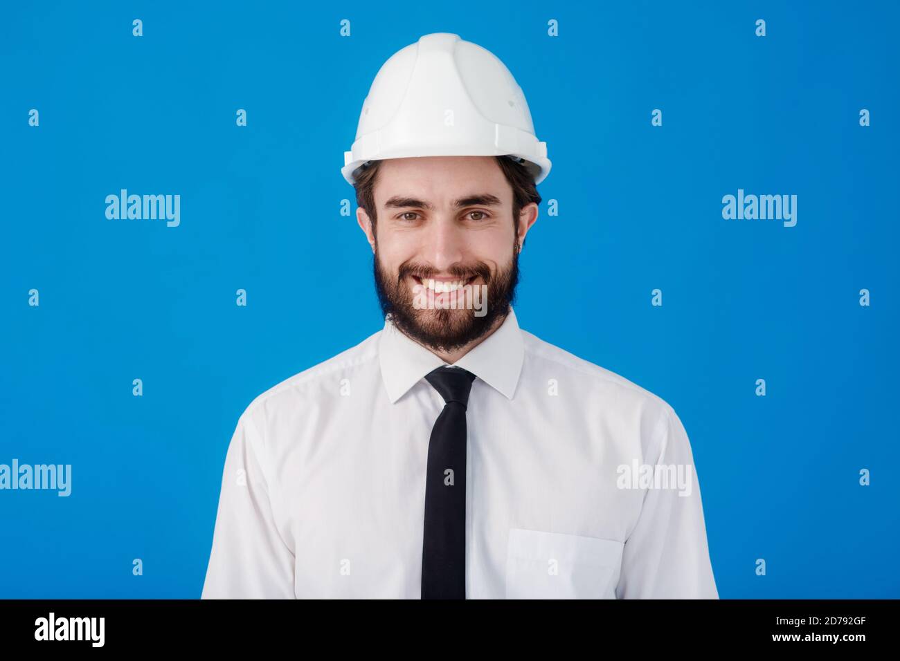 Jeune ingénieur civil barbu sur fond bleu isolé. Studio portrait de l'architecte de près Banque D'Images