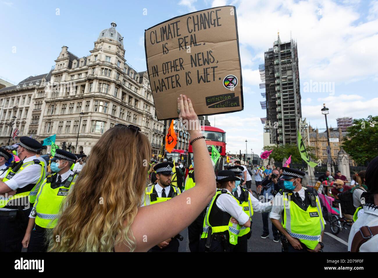 Une manifestante féminine tient une affiche devant la police, manifestation de la rébellion d'extinction, Parliament Square, Londres, 10 septembre 2020 Banque D'Images