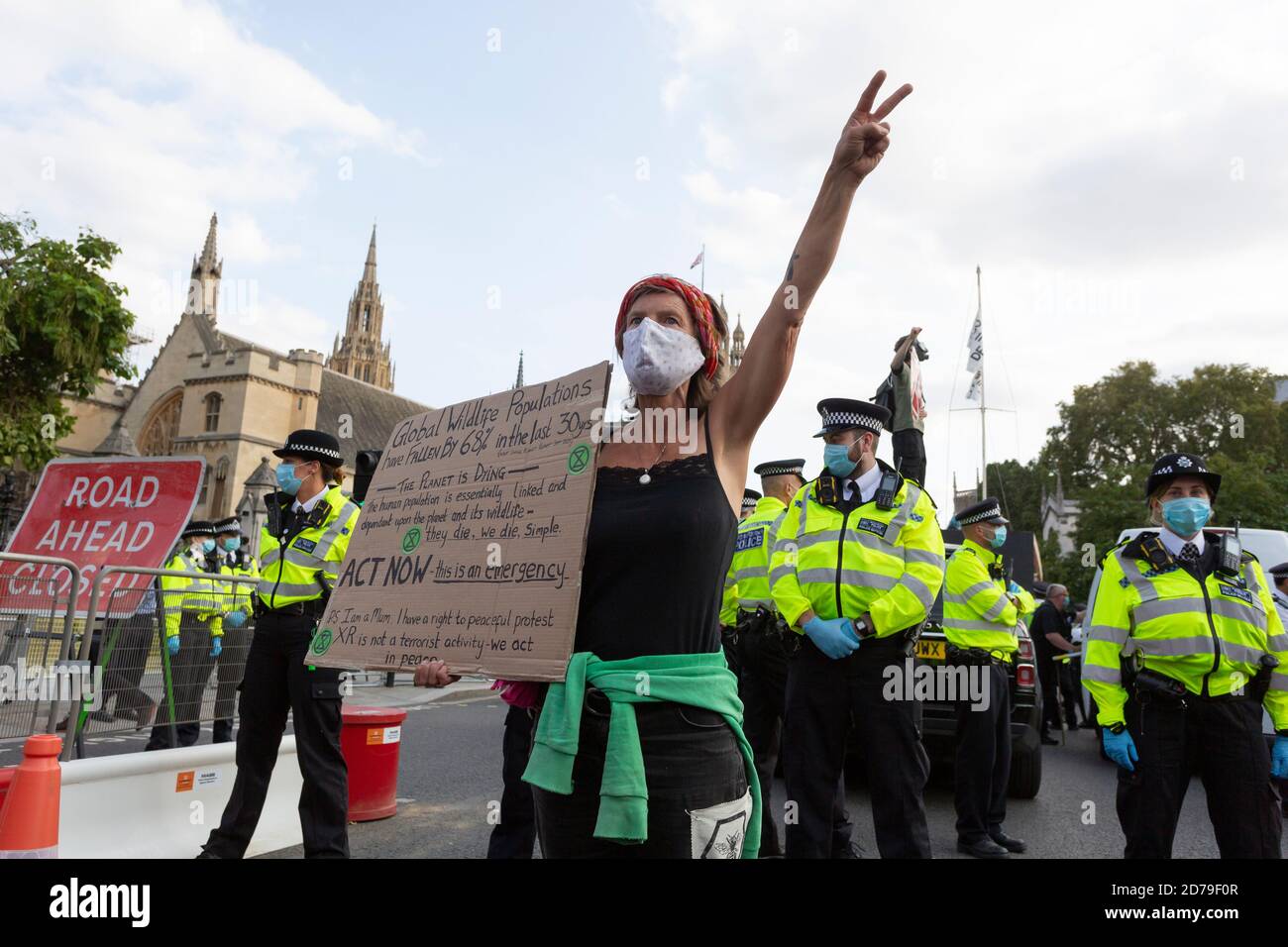 Un manifestant avec un écriteau marque le signe de paix devant la police, manifestation de la rébellion d'extinction, Parliament Square, Londres, 10 septembre 2020 Banque D'Images