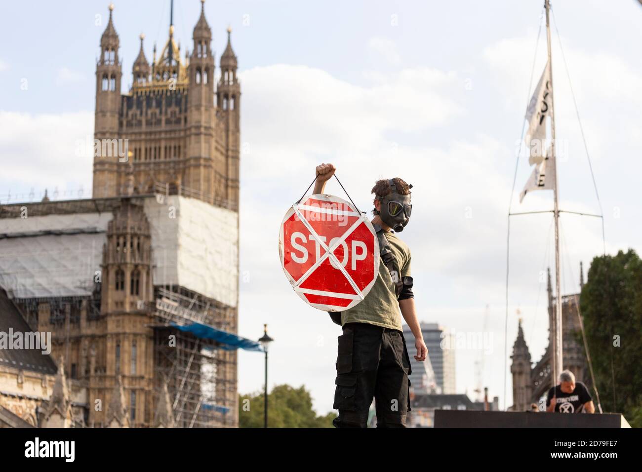 Manifestant dans un masque à gaz portant un panneau d'arrêt lors d'une manifestation de rébellion d'extinction, Parliament Square, Londres, 10 septembre 2020 Banque D'Images