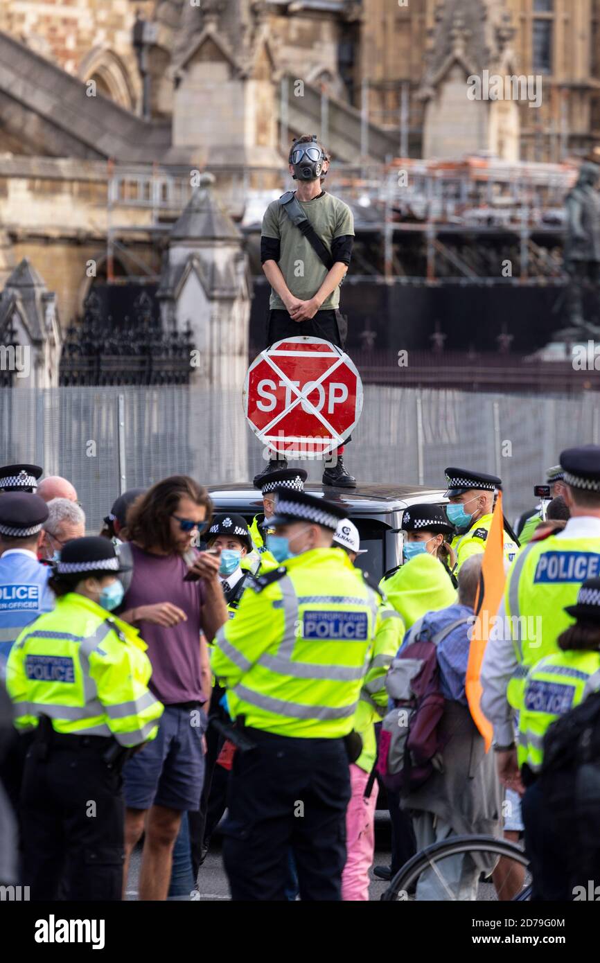 Manifestant dans un masque à gaz tenant un panneau d'arrêt et debout sur le toit de la voiture lors d'une manifestation de la rébellion d'extinction, Parliament Square, Londres, 10 sept Banque D'Images