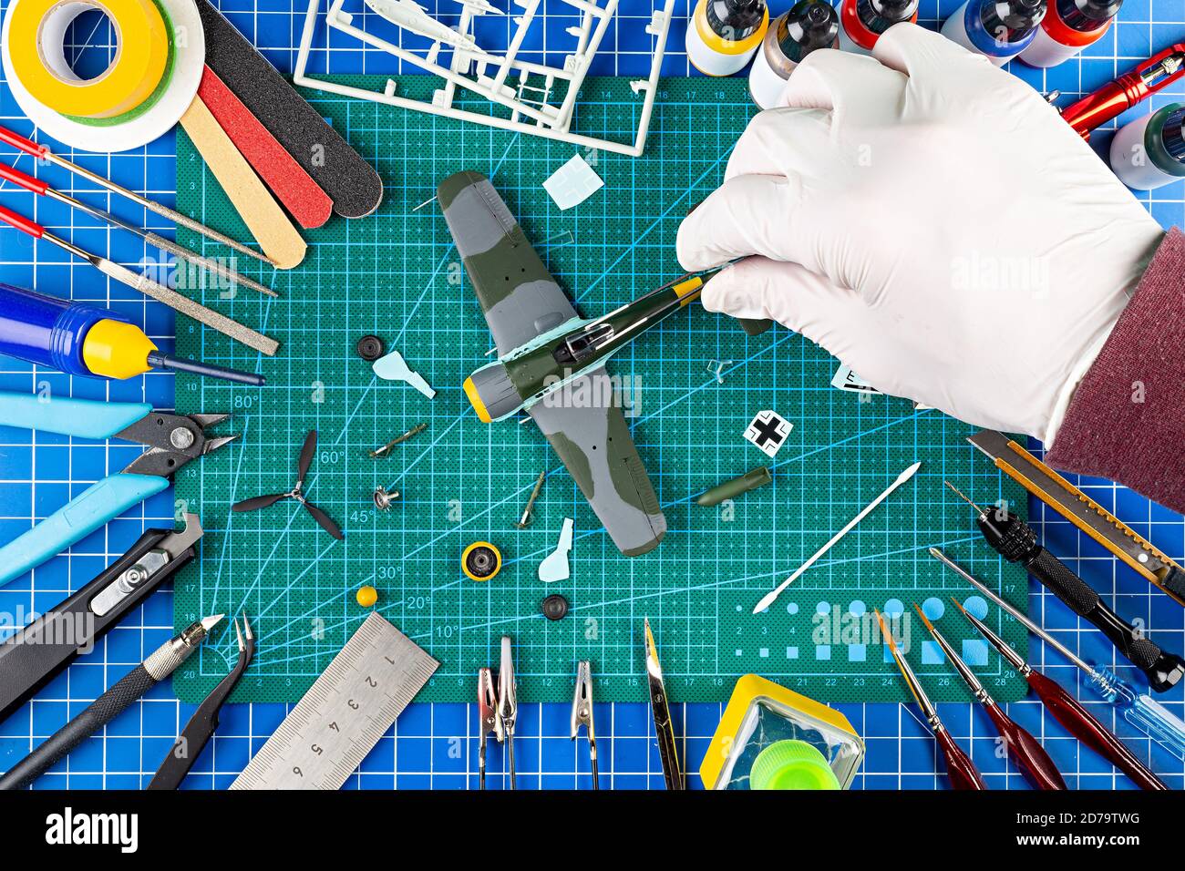 vue sur le bureau depuis le dessus de l'assemblage et la peinture de l'arrière-plan du concept d'avion de chasse modèle rétro. outils de modélisation aérographe pistolet pièces de kit de peinture bl Banque D'Images