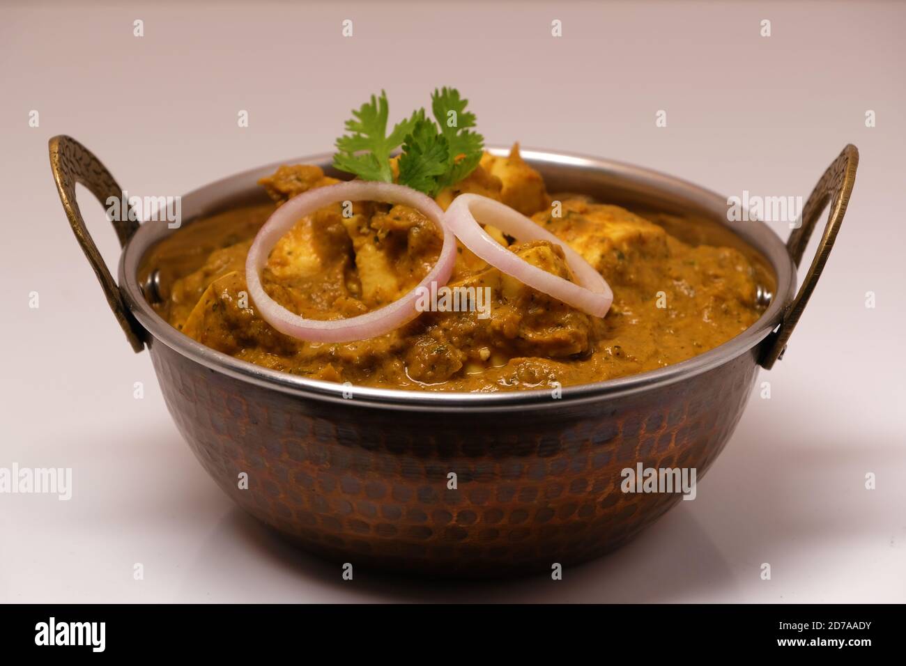 La nourriture indienne ou indien Curry dans un cuivre laiton bol de service. Banque D'Images