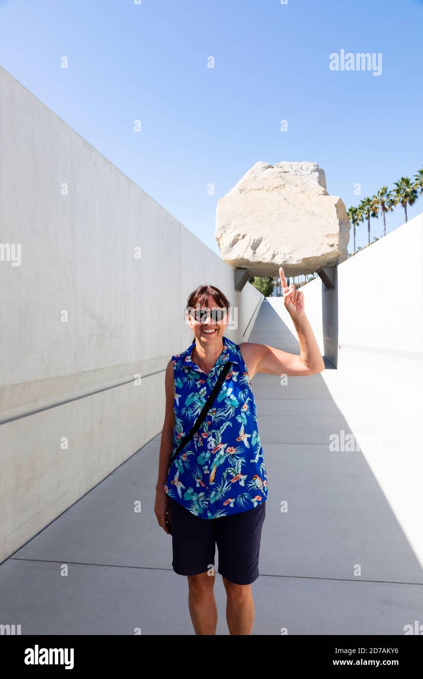 Le touriste féminin pose avec l'installation d'art de blocs de masse levitée à la LACMA, Los Angeles, Californie, États-Unis d'Amérique, États-Unis Banque D'Images
