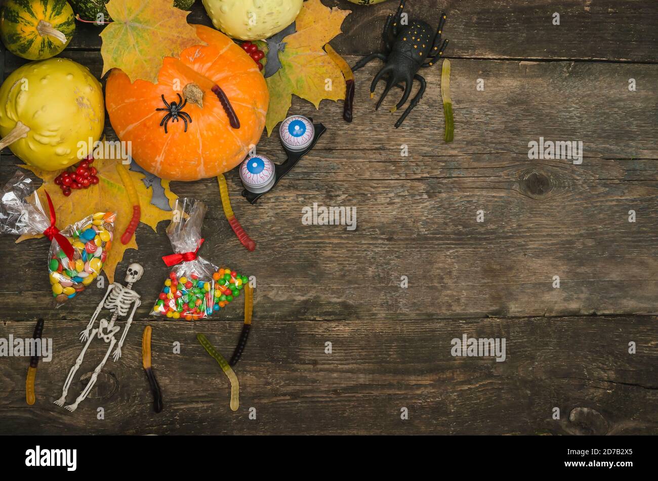 Fond de carte postale d'Halloween, citrouilles et bonbons sur un fond en bois ancien avec espace de copie. Banque D'Images