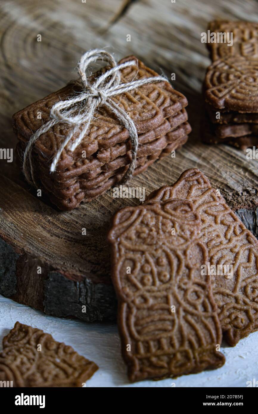 Atmosphère de l'Avent et de Noël, spéculoos empilés et reliés par un ruban d'emballage, joliment décorés sur un panneau en bois sur une table en bois blanc Banque D'Images