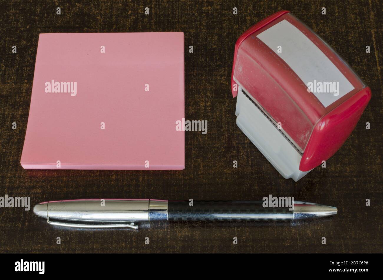 Photo à grand angle d'un stylo à bille, de notes adhésives et d'un tampon en caoutchouc sur une table Banque D'Images