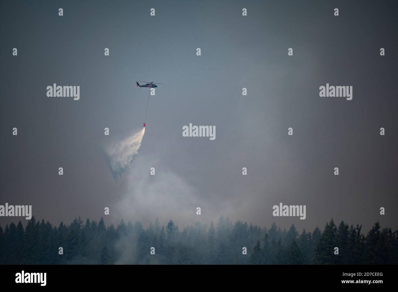 Hélicoptère larguer de l'eau sur un feu de forêt dans l'État de Washington Banque D'Images