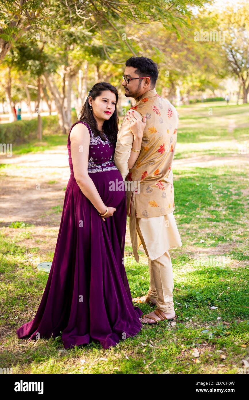 Jeune femme enceinte asiatique indienne avec son mari portant une tenue  traditionnelle debout dans un parc ou un jardin pour écrire du texte Photo  Stock - Alamy