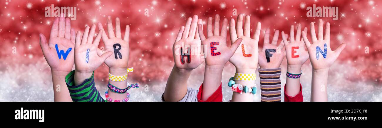 Les mains des enfants Wir Helfen signifie que nous pouvons aider, arrière-plan de Noël rouge Banque D'Images