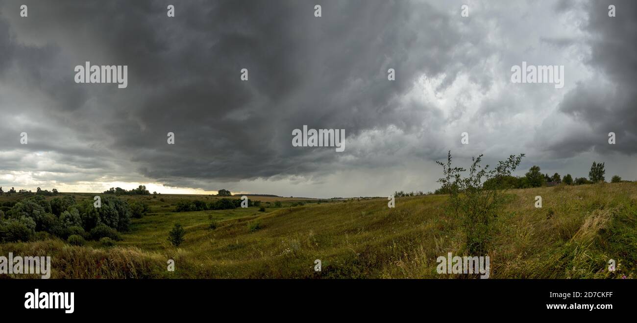 Nuages inquiétants dans le ciel couvert au-dessus des champs agricoles de blé mûr. Banque D'Images