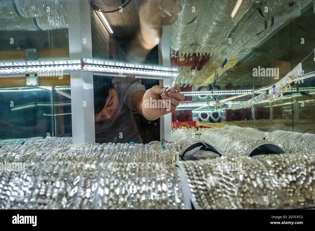 Vendeur de bijoux atteignant à l'intérieur de son vitrine, Hanoi, Vietnam Banque D'Images
