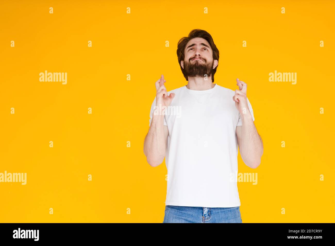 Sourire barbu homme gars en blanc décontracté t-shirt isolé sur fond jaune. Concept de mode de vie des personnes. Créer un espace de copie. En attente de spécial Banque D'Images
